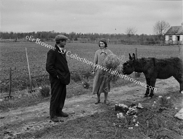 FARMER WITH WIFE FEEDING DONKEY